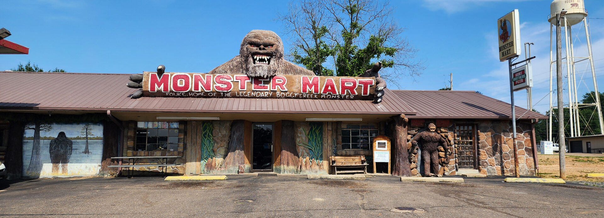 A store with an old sign and gorilla head on the roof.