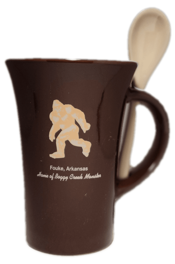 A brown coffee mug with an image of bigfoot on it.