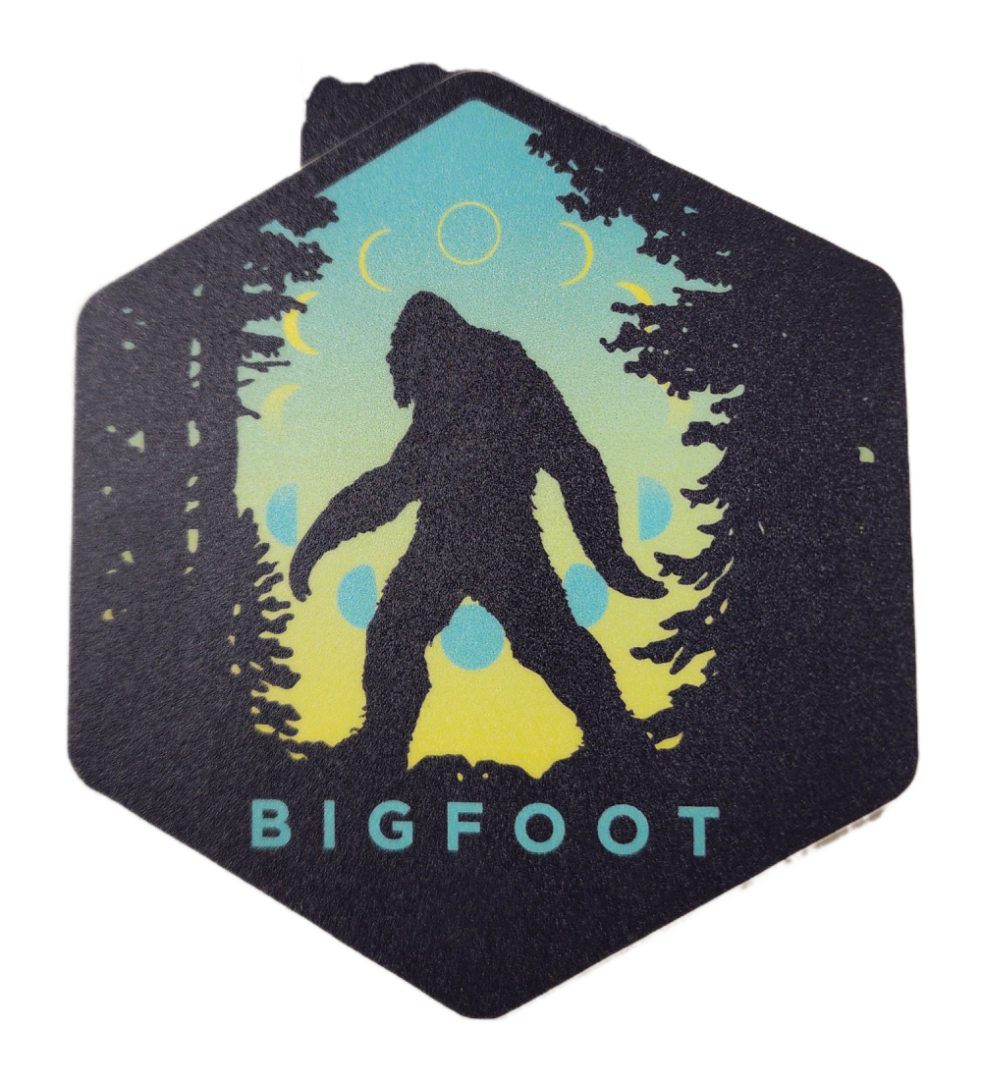 A sticker of a bigfoot in the woods.