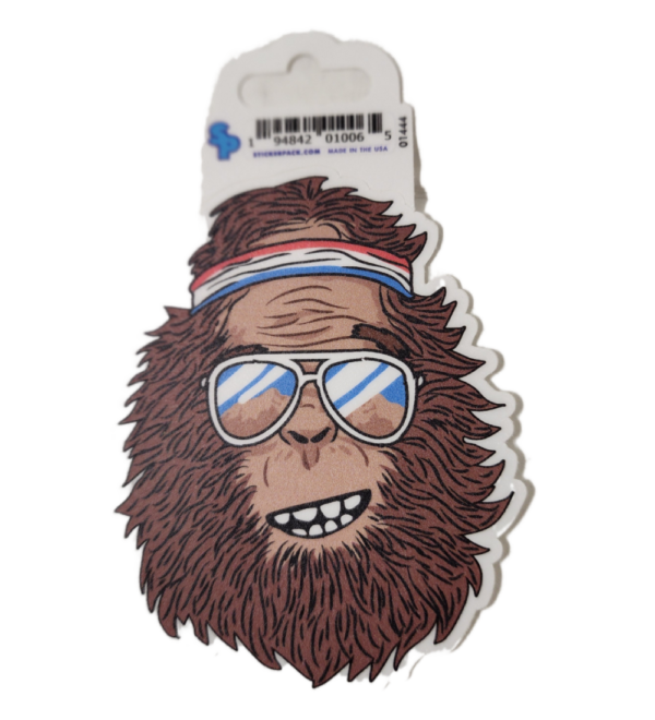 A sticker of a monkey wearing sunglasses and a hat.