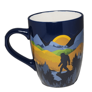 A blue coffee mug with a picture of a bear and mountains.