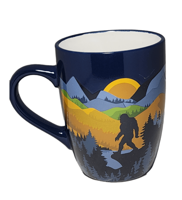 A blue coffee mug with a picture of a bear and mountains.