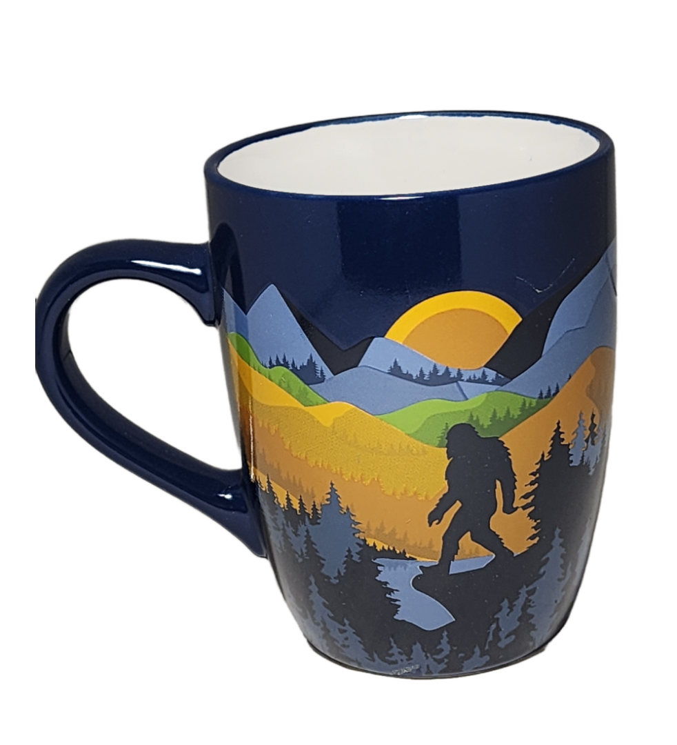 A blue coffee mug with a picture of a bear and mountains.