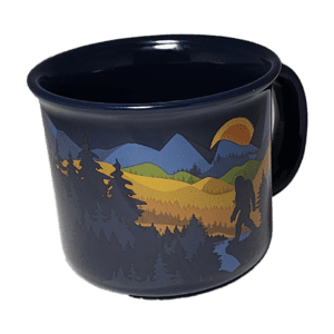 A black mug with trees and mountains on it.