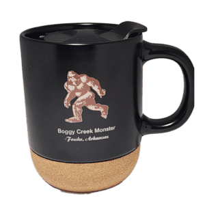 A black mug with a picture of a bigfoot on it.