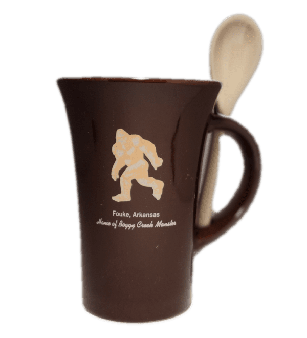 A brown coffee mug with a wooden spoon inside of it.