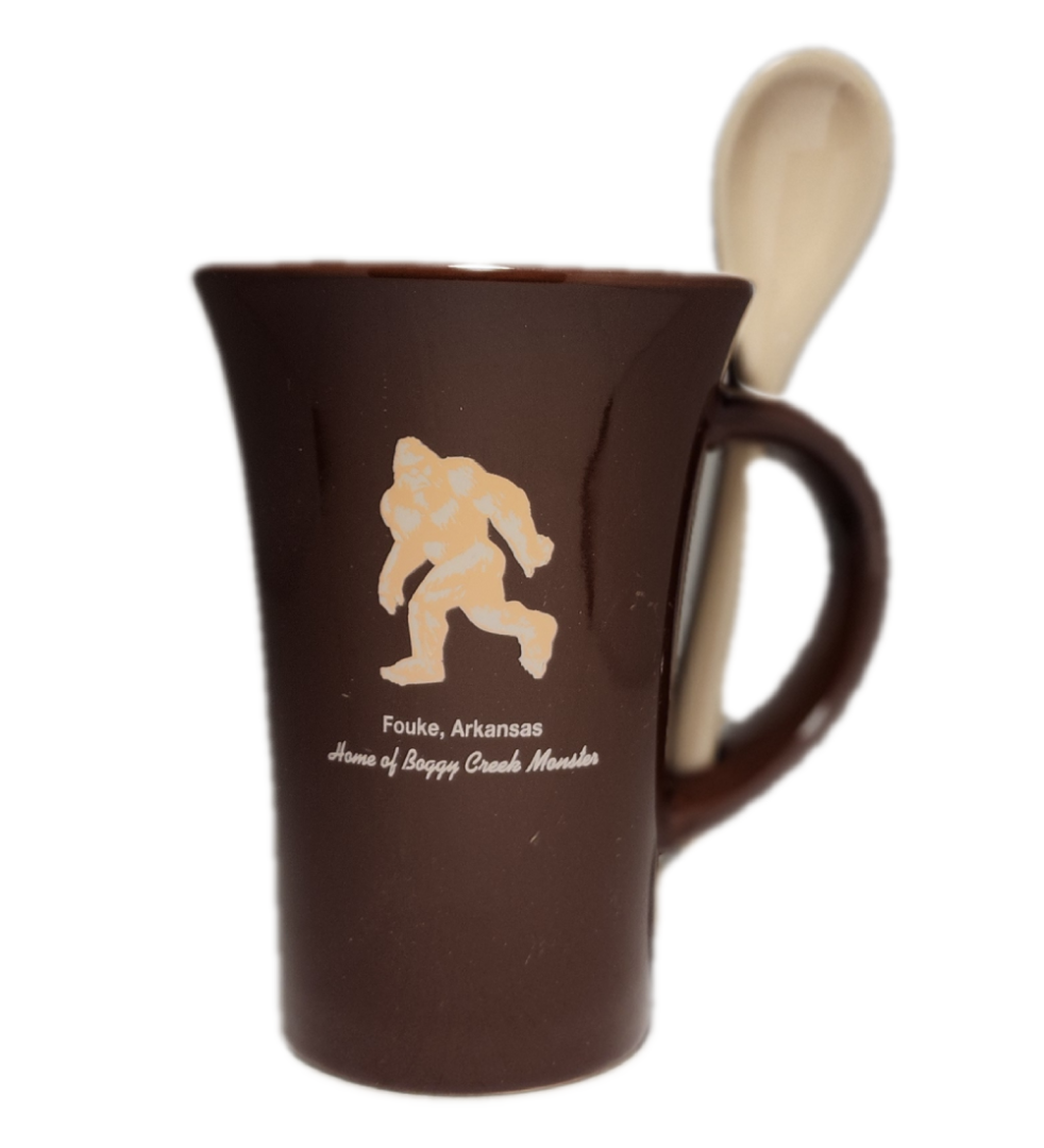 A brown coffee mug with a wooden spoon inside of it.