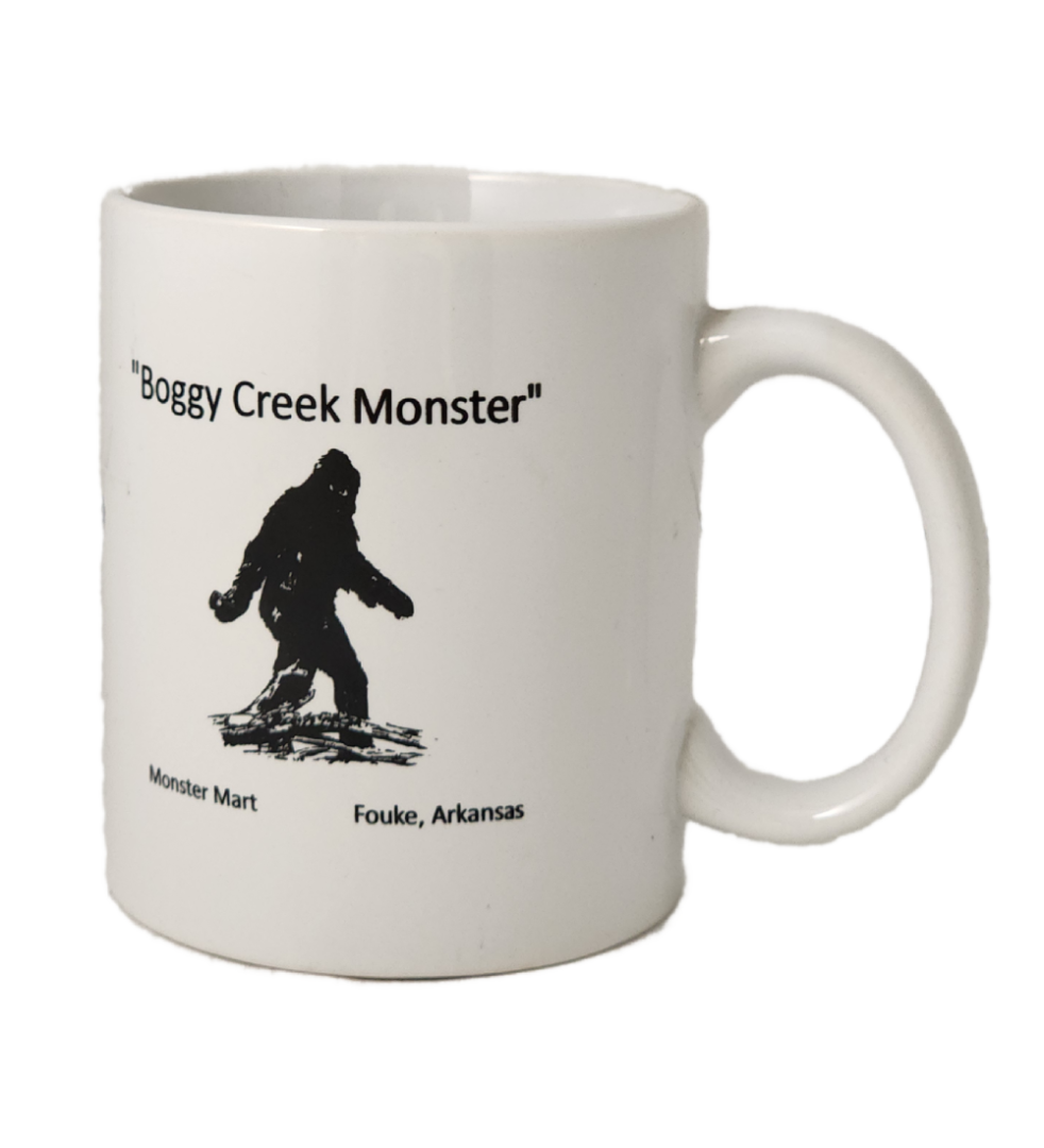 A white coffee mug with an image of a bigfoot.