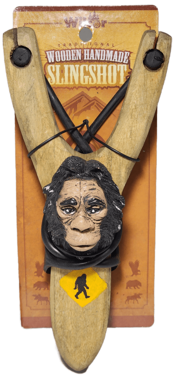 A wooden carving of an ape head hanging from a rope.