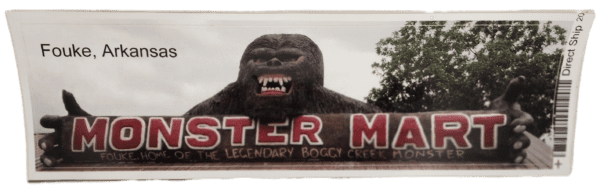 A large gorilla statue sitting in front of a monster mall sign.