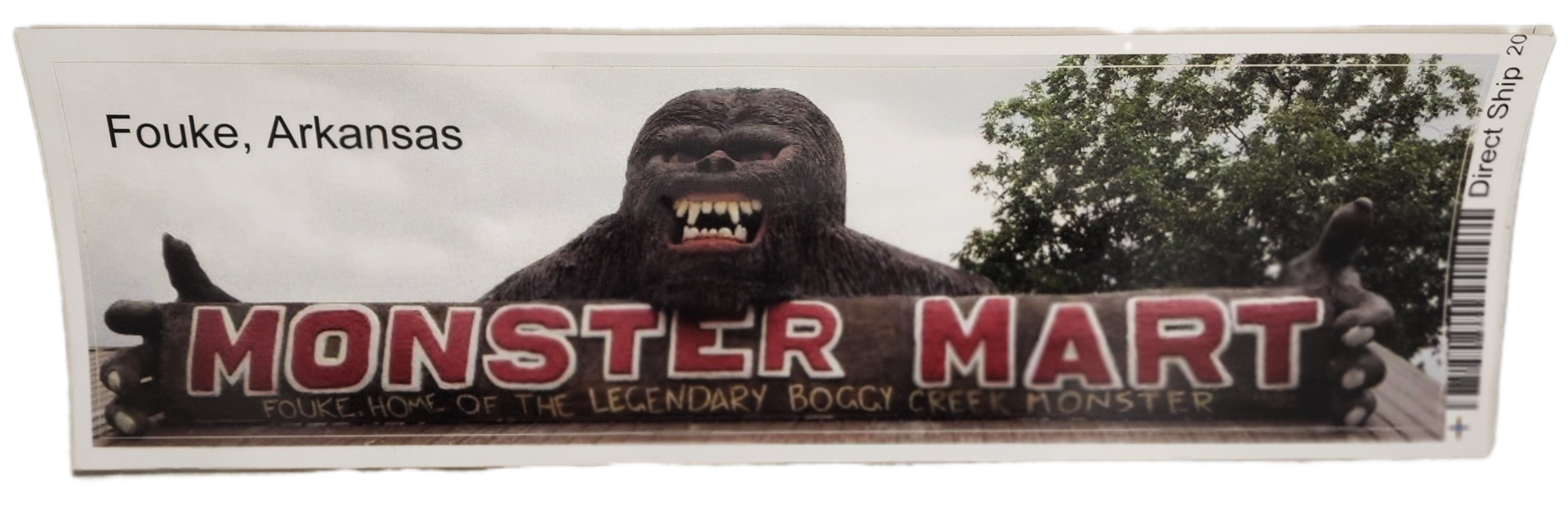 A large gorilla statue sitting in front of a monster mall sign.