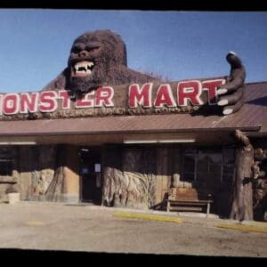 A large gorilla head sits on the roof of a store.