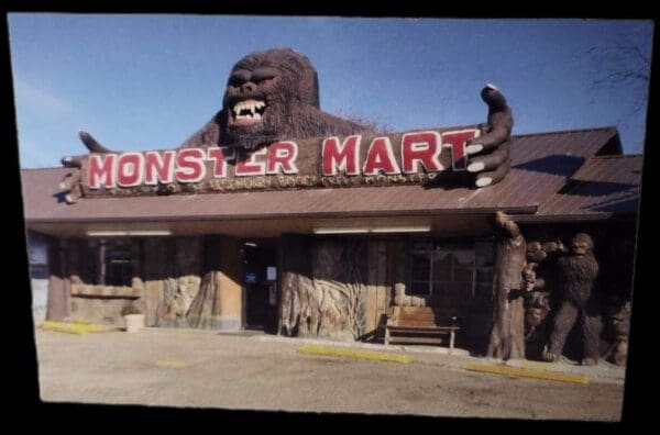 A large gorilla head sits on the roof of a store.