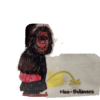 A gorilla is standing next to a banana.