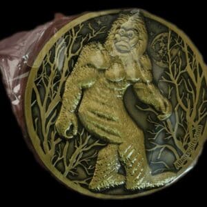 A gold medal with a picture of a bigfoot.